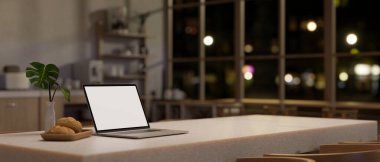 Akşamları güzel bir İskandinav mutfağında modern beyaz bir yemek masasında beyaz ekran dizüstü bilgisayar modeli. Gece konseptinde ev işi. 3d görüntüleme, 3d illüstrasyon