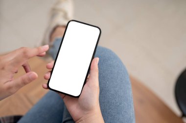 Kafede dinlenirken akıllı telefonunu kullanan bir kadın. Bir kadının elindeki akıllı telefon beyaz ekran maketi. yakın plan resim