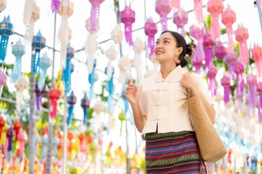 Geleneksel Tayland-Lanna elbisesi giymiş güzel ve mutlu bir Asyalı-Taylandlı kadın Tayland-Lanna fener festivalinde ya da Chiang Mai 'de bir tapınakta Yi Peng' in keyfini çıkarıyor. Lanna Loy Krathong Festivali