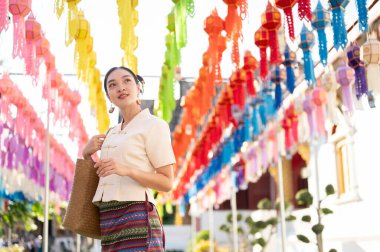 Geleneksel Tayland-Lanna elbisesi giymiş güzel ve mutlu bir Asyalı-Taylandlı kadın Tayland-Lanna fener festivalinde ya da Chiang Mai 'de bir tapınakta Yi Peng' in keyfini çıkarıyor. Lanna Loy Krathong Festivali
