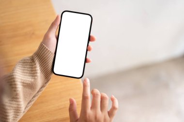 Kapalı alanda akıllı telefonunu kullanan bir kadının yakın plan görüntüsü, bir kadının elinde beyaz ekran akıllı telefon modeli..