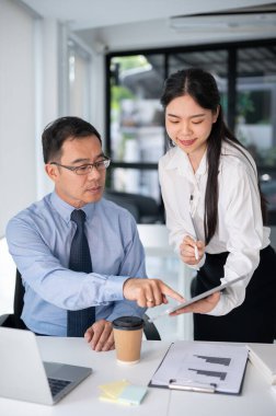 Genç ve güzel bir iş kadını ofis odasındaki kıdemli amirden tavsiye istiyor. İş insanları kavramı.