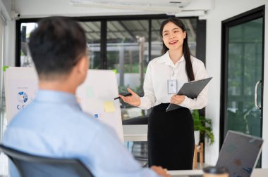 Genç bayan ofis çalışanı iş fikrini toplantı odasında üst düzey yöneticisine sunar. İş planını sunuyorum..