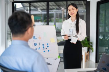 Genç bayan ofis çalışanı iş fikrini toplantı odasında üst düzey yöneticisine sunar. İş planını sunuyorum..