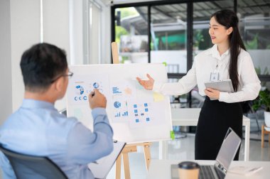 Genç bayan ofis çalışanı iş fikrini toplantı odasında üst düzey yöneticisine sunar. İş planını sunuyorum..