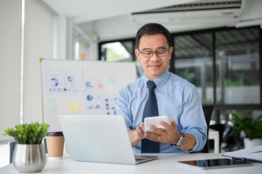 Hesap makinesiyle çalışan deneyimli kıdemli işadamı, projenin bütçesini yönetiyor. Kıdemli işadamı