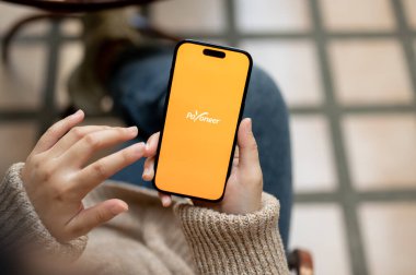 Chiang Mai, Tayland - 21 Kasım 2023: Açık havada otururken Payonez uygulamasını kullanan bir kadının yakın plan görüntüsü. IPhone14 ekranında herhangi birinin logosu. İnsanlar ve teknoloji kavramları
