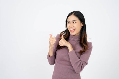Genç Asyalı iş kadını, gülümseyen ve parmakla işaret eden, ürün öneren, öven, beyaz arka planda duran.
