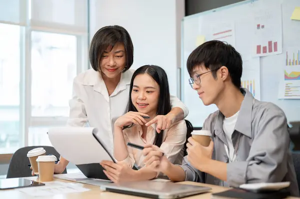Group of cheerful diverse Asian businesspeople are in the meeting, checking a new project details in reports together. Teamwork, team building, co-working, brainstorming