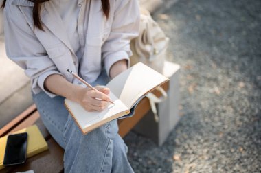 Günlük kıyafetlerle gezen genç bir Asyalı kadının görüntüsü ya günlüğünü tutar ya da parkta bir bankta dinlenirken defterine not alır. Öğrenci, serbest çalışan, boş zaman ve yaşam tarzı