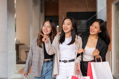 Genç mutlu Asyalı kızlar hafta sonunu şehirde birlikte geçiriyorlar, alışveriş günlerinin tadını çıkarıyorlar. Şehir hayatı, arkadaşlık ve yaşam tarzı kavramları