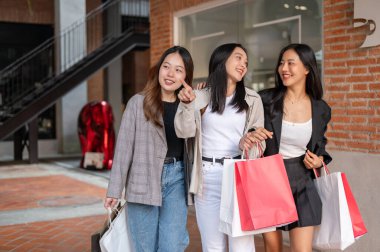 Alışveriş torbalarıyla şık giyinmiş bir grup çekici Asyalı genç kız hafta sonu birlikte şehirde alışverişin keyfini çıkarıyorlar. Flaşlı satış, Mega satış, moda ve yaşam tarzı