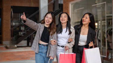 Bir grup çekici ve eğlenceli Asyalı kız şehirde alışveriş yapmaktan, alışveriş torbalarıyla gezmekten ve hafta sonunu birlikte geçirmekten keyif alıyorlar. Moda ve yaşam tarzı kavramları