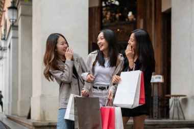 Moda kıyafetleri içinde neşeli ve çekici Asyalı kadınlar şehirde konuşmaktan, gülmekten ve alışveriş yapmaktan keyif alıyorlar. Şehir hayatı, moda, yaşam tarzı, arkadaşlık