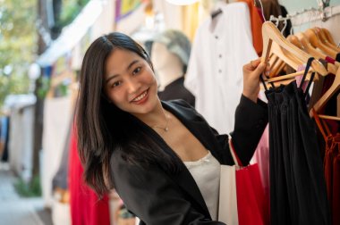 Güzel bir Asyalı dişi hafta sonları şehirde tek başına alışveriş yapmaktan zevk alır, güzel elbiseler seçer. Moda ve yaşam tarzı kavramları