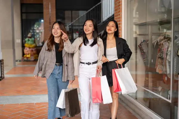 Genç mutlu Asyalı kızlar hafta sonunu şehirde birlikte geçiriyorlar, alışveriş günlerinin tadını çıkarıyorlar. Şehir hayatı, arkadaşlık ve yaşam tarzı kavramları