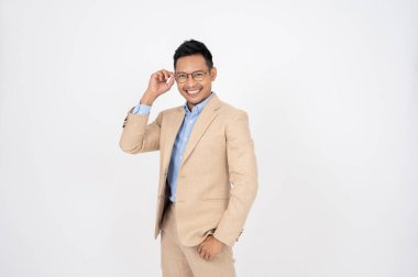 Resmi takım elbiseli yakışıklı, zeki Asyalı bir işadamı izole edilmiş beyaz bir stüdyo geçmişine karşı duruyor. İş adamları konsepti