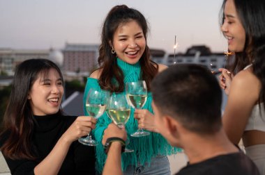 Bir grup mutlu ve çekici Asyalı genç arkadaş gece vakti şampanya içip çatıdaki bir barda parti yapıyorlar. Kutlama, şehir hayatı, arkadaşlık, özel an