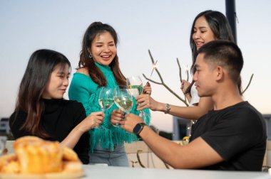 Bir grup mutlu ve çekici Asyalı genç arkadaş gece vakti şampanya içip çatıdaki bir barda parti yapıyorlar. Kutlama, şehir hayatı, arkadaşlık, özel an