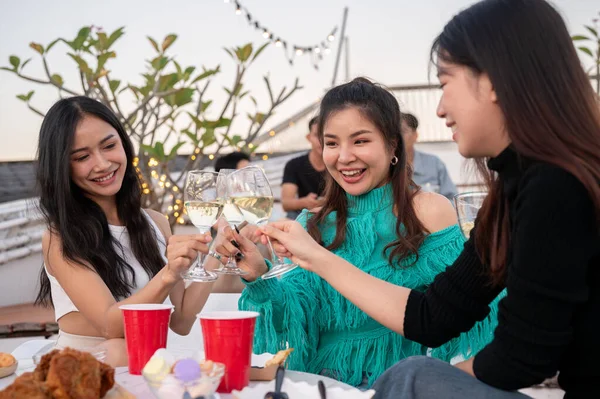 Bir grup çekici Asyalı genç bayan arkadaş şampanya içiyor, kutlama yapıyor, eğleniyor ve çatıdaki bir barda parti yapıyorlar. Şehir hayatı, kızlar gecesi, arkadaşlık, yaşam tarzı.