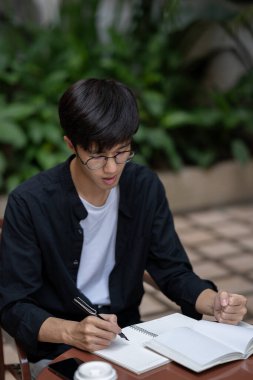 Tatminsiz ve mutsuz bir Asyalı adam dışarıda bir masada zor bir sorunla karşı karşıya..