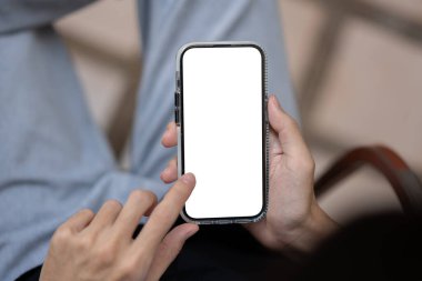 Akıllı telefonunu kullanan, ekrana dokunan, dışarıda otururken web sitesine veya sosyal medyaya kayan bir adamın yakın plan görüntüsü. Akıllı telefon maketi. İnsanlar ve teknoloji kavramları