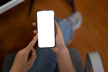 Ofiste akıllı telefonunu kullanan bir kadının en iyi görüntüsü. Grafik reklamlarınızı göstermek için beyaz ekran akıllı telefon modeli. İnsanlar ve teknoloji kavramları