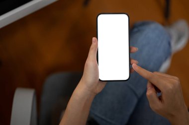 Ofiste akıllı telefonunu kullanan bir kadının en iyi görüntüsü. Grafik reklamlarınızı göstermek için beyaz ekran akıllı telefon modeli. İnsanlar ve teknoloji kavramları