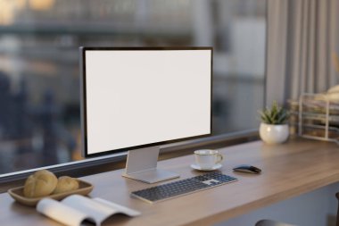 Şehir manzaralı büyük cam pencereye karşı beyaz ekran bilgisayar modellemesi ve aksesuarları olan modern bir ofis çalışma alanı. 3d görüntüleme, 3d illüstrasyon