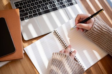 Rahat örülü bir süveter giyen bir kadının en iyi görüntüsü elinde kalem tutarken, bir şeyler yazarken ya da bilgisayarında bilgisayarla çalışırken not alırken görülüyor..