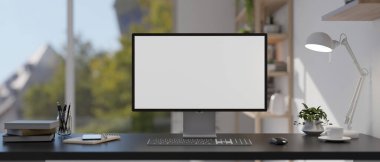 Modern bir ev ofisinde masanın üzerinde beyaz ekran bir bilgisayar modeli, bir masa lambası ve aksesuarlar bulunur. 3d görüntüleme, 3d illüstrasyon