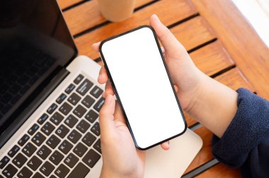 Kafede uzaktan çalışırken akıllı telefonunu kullanan bir kadının en iyi görüntüsü. Grafik reklamlarınızı göstermek için beyaz ekran akıllı telefon modeliName.