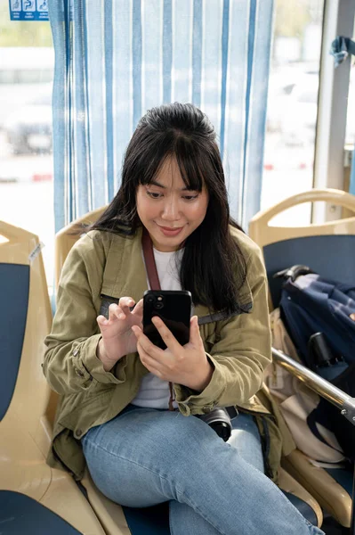 A happy young Asian female enjoying chatting with her friends while on a public bus. modern city life concept