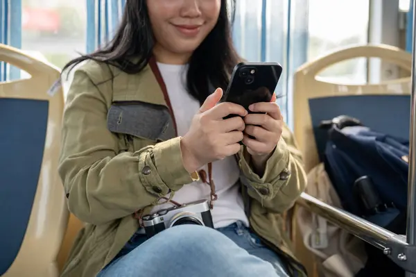 A happy young Asian female enjoying chatting with her friends while on a public bus. modern city life concept. a cropped shot