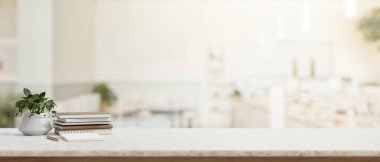 Beyaz masa, kitaplar, bir dekor bitkisi ve modern parlak mutfak veya kafenin bulanık arka planına sahip ürünler için bir kopya alanı içerir. 3d görüntüleme, 3d illüstrasyon