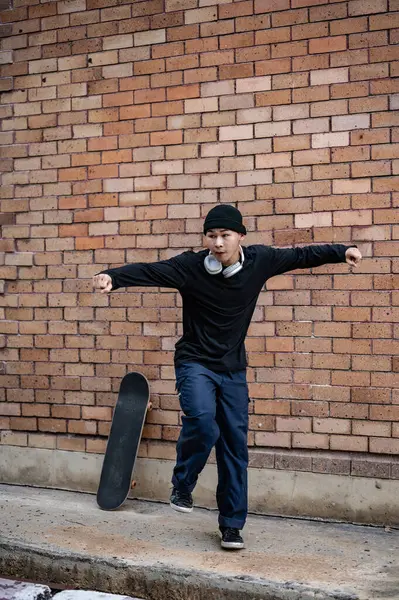 stock image A cool and talented Asian man in fashionable clothes is dancing on the street, practicing his breakdance performance outdoors. b-boy, hiphop dance, free style dance