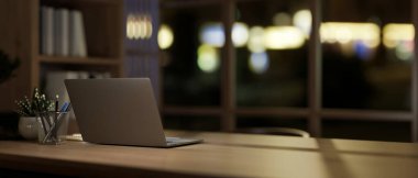 Akşamları modern bir ofisteki ahşap bir masadaki dizüstü bilgisayarın arka plan görüntüsü. Görüntüyü yaklaştır. 3d görüntüleme, 3d illüstrasyon