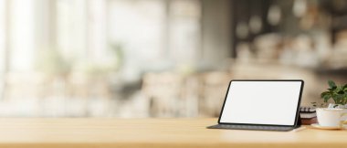 Rahat, minimalist bir kahve dükkanının ahşap masasında kablosuz klavyesi olan beyaz ekran dijital bir tablet. 3d görüntüleme, 3d illüstrasyon