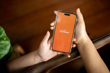 Chiang Mai, Tayland - Nisan 03 2024: iPhone14 ekranındaki Payonez logosu, kapalı alanda otururken Payonez uygulamasını kullanan bir kadın.