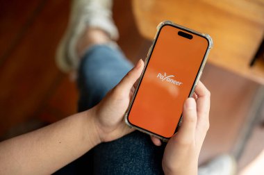 Chiang Mai, Tayland - Nisan 03 2024: iPhone14 ekranındaki Payonez logosu, kapalı alanda otururken Payonez uygulamasını kullanan bir kadın.