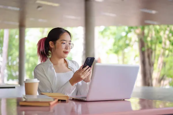 Молодая Позитивная Азиатская Студентка Колледжа Использующая Свой Смартфон Проверять Сообщения Лицензионные Стоковые Фото
