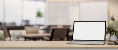 Çağdaş bir toplantı odasının bulanık arka planına sahip bir masada beyaz ekran dizüstü bilgisayar modeli. İş yeri konsepti. 3d görüntüleme, 3d illüstrasyon