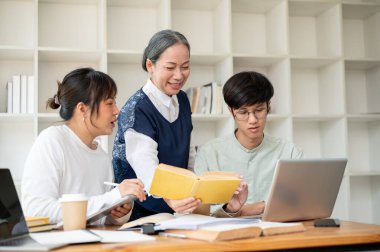Olumlu ve olgun bir Asyalı kadın profesör öğrencilerine sınıfta yardım ediyor, bazı zor konuları anlatıyor, ev ödevlerini öğretiyor ve tartışıyor, dizüstü bilgisayar ve kitaba birlikte bakıyor..