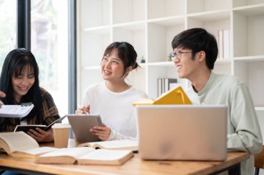 Bir grup neşeli Asyalı üniversite öğrencisi sınıfta öğretmenleriyle ders çalışmaktan zevk alıyor. Öğrenciler öğretmenlerinin bir şey açıklamasını dinliyorlar. eğitim kavramı