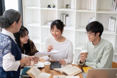 Bir grup neşeli Asyalı üniversite öğrencisi sınıfta olgun bir bayan profesörle matematik çalışmaktan zevk alıyor. eğitim kavramı