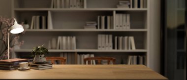 Uzun ahşap bir masa kitapları, bir masa lambası, bir kahve fincanı, bir saksı bitkisi ve geceleri bir okuma odasında veya ofiste büyük bir kitaplığa karşı bir kopya alanı içerir. 3d görüntüleme, 3d illüstrasyon