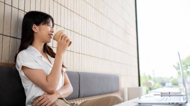 Güzel bir Asyalı kadın kameradan uzağa bakıyor, dışarıdaki manzaraya bakıyor, hayal kuruyor, bir şeyler düşünüyor, kafeteryada kahve içerken kendini kaybetmiş..