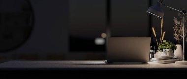 Geceleri modern bir karanlık ofiste dizüstü bilgisayar, dekoratif nesneler ve masa lambasından loş bir ışık bulunur. Görüntüyü yaklaştır. 3d görüntüleme, 3d illüstrasyon