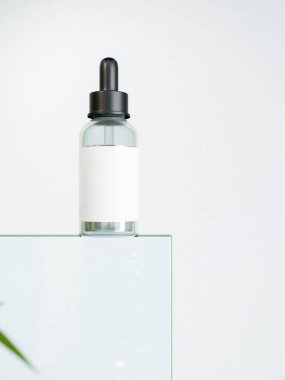 Beyaz arka planda kaidede serum kozmetik şişeleri. Şeffaf yüz bakımı düşürücü serum şişesi ve beyaz etiket modeli. 3d görüntüleme, 3d illüstrasyon