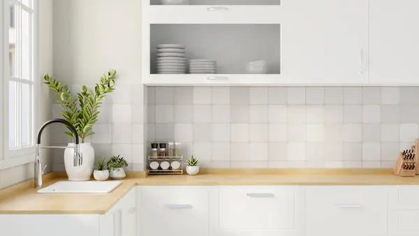 Minimalist beyaz bir mutfağın iç tasarımında bir lavabo, dekor bitkileri ve ahşap mutfak tezgahında çeşnili bir raf ve fayanslı bir duvarda beyaz bir dolap bulunur. 3d görüntüleme, 3d illüstrasyon